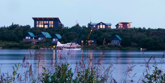 Small airplane on a lake with cabins in the background