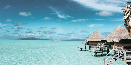 Overwater bungalows with a clear blue sky and turquoise water