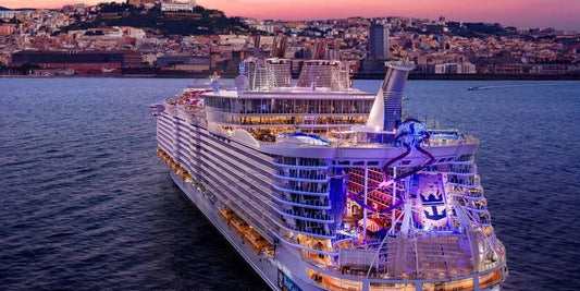 Cruise ship 'Allure of the Seas' sailing on water with a cityscape in the background